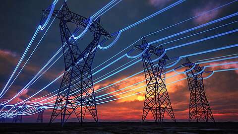 Hochspannungsleitungen auf hohen Masten erstrecken sich bei Sonnenuntergang über die Landschaft, wobei blau leuchtende Linien hinzugefügt wurden, um den Stromfluss durch die Kabel zu veranschaulichen.
